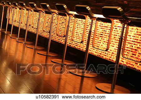 Stock Image - Bar stools in a row in front of bar counter with modern style. Fotosearch