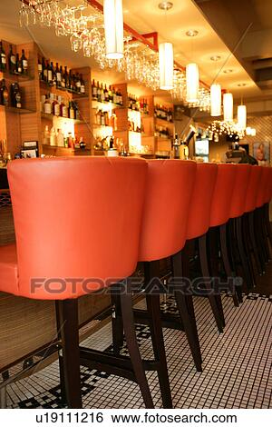 Stock Photograph - Bar stools in a row in front of bar counter with modern style. Fotosearch