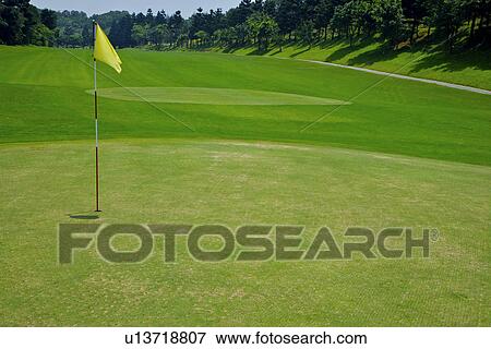 Stock Photo - Yellow flag in golf course. Fotosearch