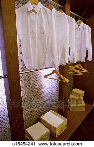 Stock Image - Interiors of a walk-in wardrobe with shirts. Fotosearch