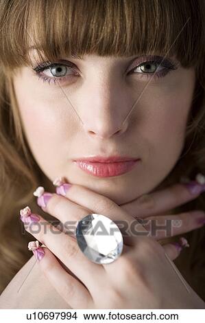 Studio shot of teenage girl with makeup showing ring View Large Photo Image Picture - Studio shot of teenage girl with makeup showing ring. Fotosearch