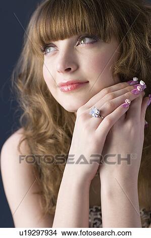 Picture - Studio shot of teenage girl with makeup and artificial fingernails. Fotosearch