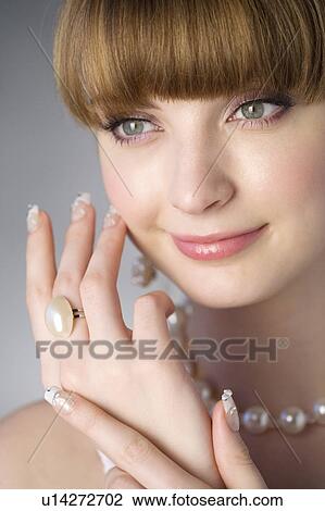 Stock Image - Studio shot of teenage girl with makeup and artificial fingernails. Fotosearch