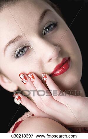 Stock Photo - Studio shot of teenage girl with makeup and artificial fingernails. Fotosearch