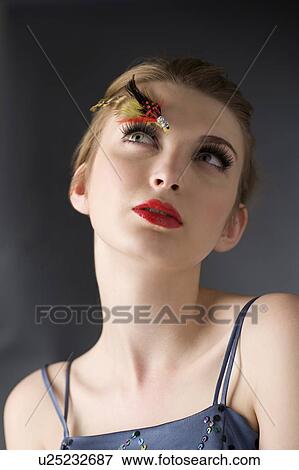 Stock Photo - Studio shot of teenage girl with makeup, looking up. Fotosearch