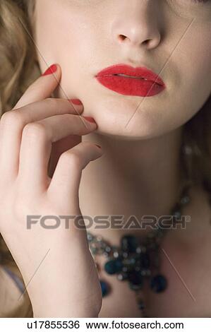 Stock Photograph - Studio shot of teenage girl with makeup, focus on part of face and hand. Fotosearch