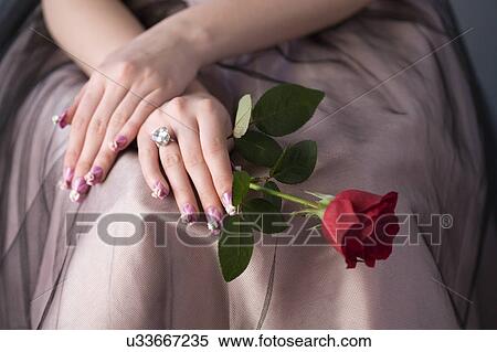Studio shot of teenage girl with single rose and artificial fingernails View Large Photo Image Stock Photography - Studio shot of teenage girl with single rose and artificial fingernails. Fotosearch