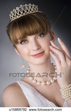 Stock Image - Studio shot of teenage girl with jewelries and artificial fingernails. Fotosearch