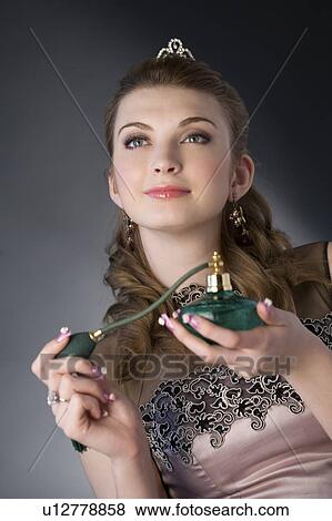 Teenage girl in formal dress holding perfume sprayer View Large Photo Image Stock Photo - Teenage girl in formal dress holding perfume sprayer. Fotosearch