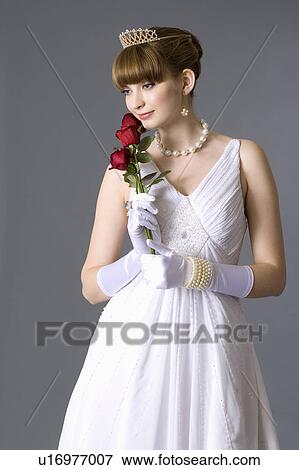 Stock Photo - Teenage girl in formal dress holding roses. Fotosearch