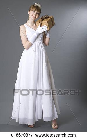 Teenage girl in formal dress holding wrapped gift View Large Photo Image Stock Photo - Teenage girl in formal dress holding wrapped gift. Fotosearch