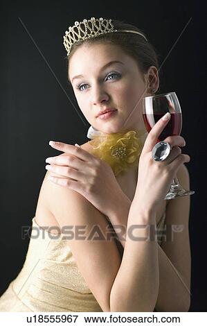Stock Photo - Teenage girl wearing jewelries holding a glass of wine. Fotosearch