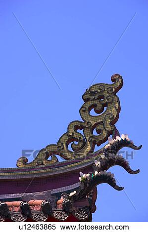 Stock Photography - Chinese traditional building with sculpture on roof against blue sky. Fotosearch