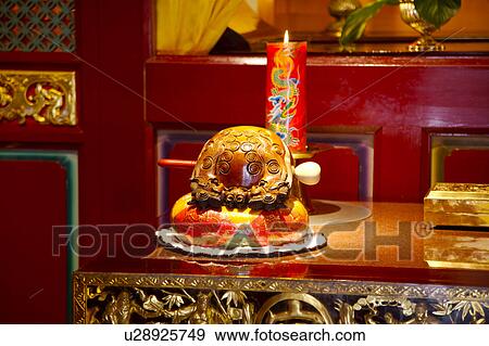 Stock Photo - Chinese wood block and burning candle on table. Fotosearch