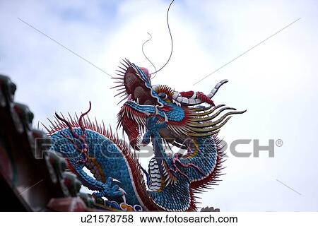 Stock Photo - Dragon sculpture on roof against sky. Fotosearch