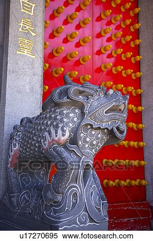 Stock Photography - Lion statue by red door. Fotosearch