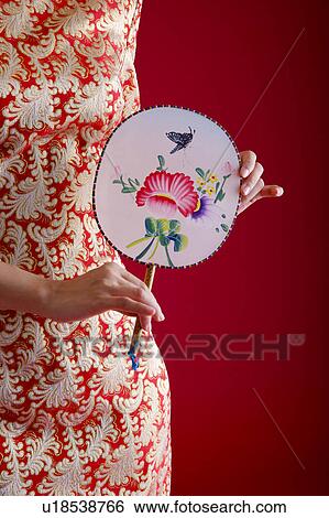 Woman in Cheongsam holding fan, mid section View Large Photo Image Stock Photograph - Woman in Cheongsam holding fan, mid section. Fotosearch
