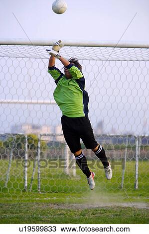 Stock Image - Football goalie diving for ball. Fotosearch