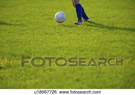 Stock Photograph - Person playing soccer ball, mid section. Fotosearch
