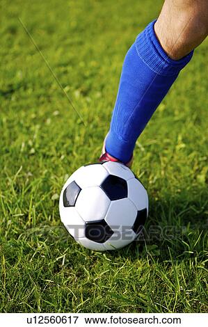 Stock Photo - Soccer ball on player's foot, focus on foot. Fotosearch