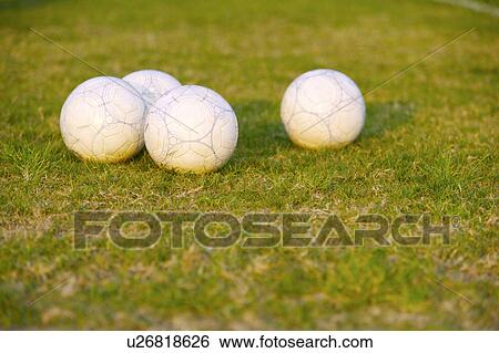 Stock Photograph - Soccer balls on grass. Fotosearch
