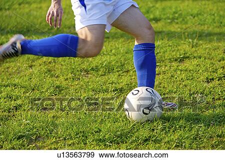 Soccer player kicking ball, mid section View Large Photo Image Stock Photo - Soccer player kicking ball, mid section. Fotosearch