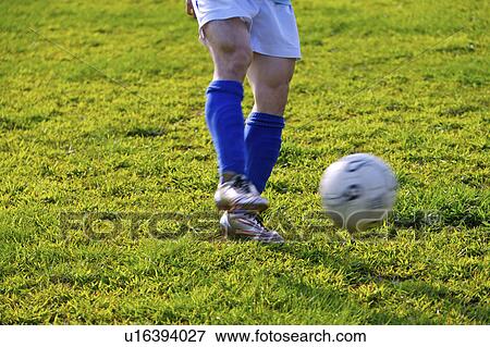 Soccer player kicking ball, mid section View Large Photo Image Stock Photo - Soccer player kicking ball, mid section. Fotosearch
