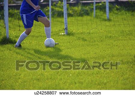 Soccer player kicking ball, mid section View Large Photo Image Stock Photo - Soccer player kicking ball, mid section. Fotosearch