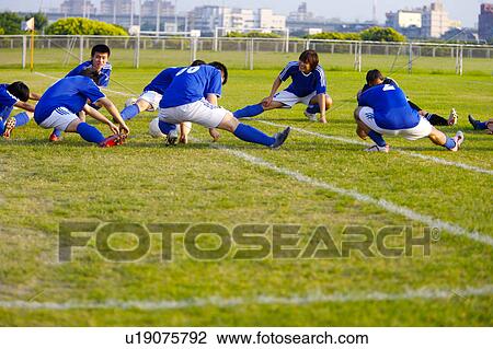 Stock Image - Soccer players warming up on pitch. Fotosearch