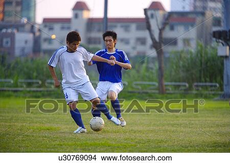 Two soccer players kicking ball View Large Photo Image Picture - Two soccer players kicking ball. Fotosearch