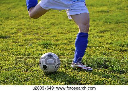 Young man kicking soccer ball, mid section View Large Photo Image Stock Photo - Young man kicking soccer ball, mid section. Fotosearch