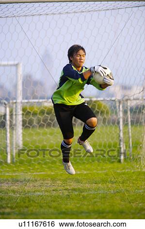Stock Photograph - Young soccer goalie catching ball. Fotosearch
