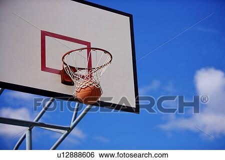 Basketball going through hoop View Large Photo Image Stock Photograph - Basketball going through hoop. Fotosearch