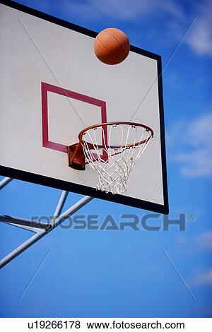 Stock Photo - Basketball over basketball hoop. Fotosearch