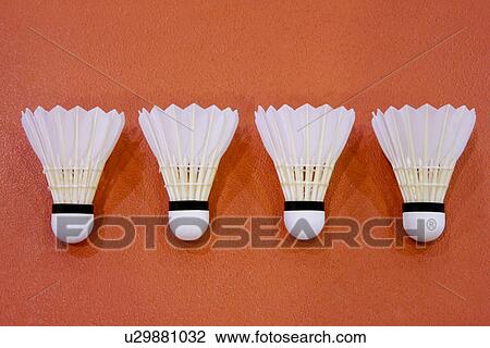 Stock Image - Four shuttlecocks in a row on badminton court. Fotosearch