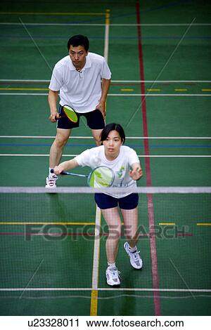 Stock Image - Man and woman, teammates, standing in preparation for a game. Fotosearch