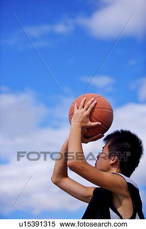 Stock Photography - Teenage boy playing basketball. Fotosearch