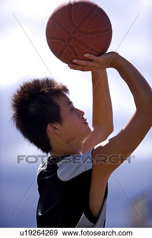 Stock Photo - Teenage boy preparing to throw basketball. Fotosearch
