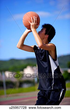 Stock Photo - Teenage boy preparing to throw basketball. Fotosearch