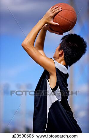Teenage boy preparing to throw basketball View Large Photo Image Stock Photography - Teenage boy preparing to throw basketball. Fotosearch