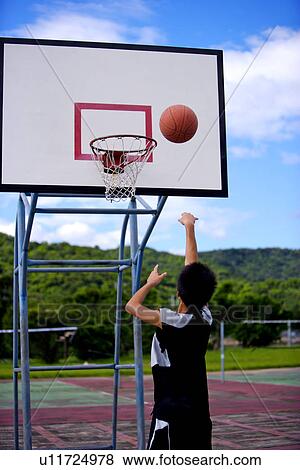 Stock Photo - Teenage boy shooting a basketball. Fotosearch