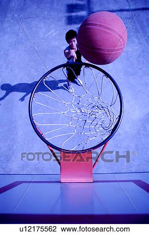 Teenage boy shooting basketball into hoop View Large Photo Image Stock Image - Teenage boy shooting basketball into hoop. Fotosearch