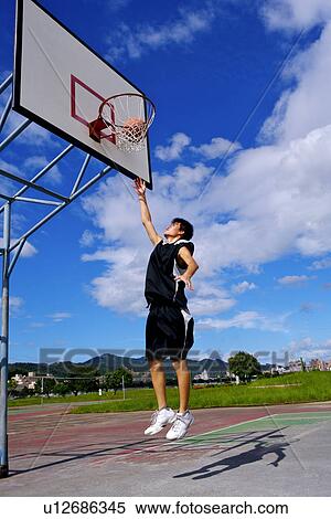 Stock Photography - Teenage boy throwing basketball through net. Fotosearch