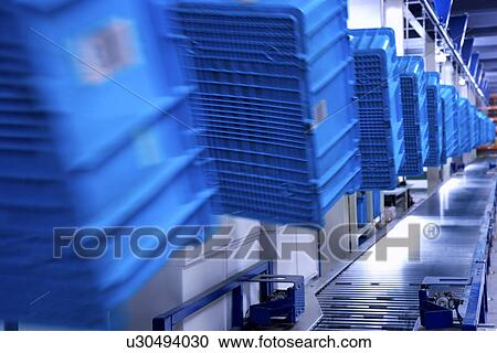 Blue plastic boxes hanging over conveyor belt View Large Photo Image Stock Image - Blue plastic boxes hanging over conveyor belt. Fotosearch