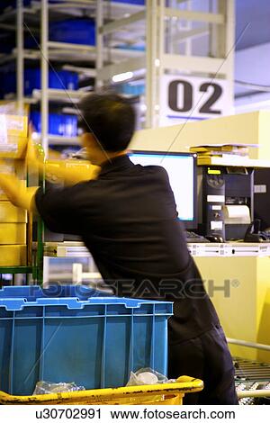 Man working in warehouse View Large Photo Image Stock Image - Man working in warehouse. Fotosearch