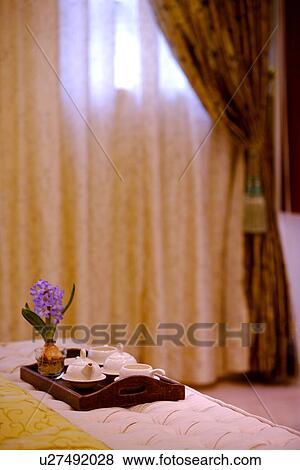 Stock Photo - Tea set on bed in bedroom. Fotosearch