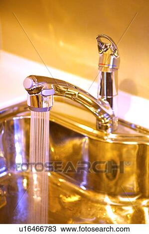Stock Image - Water flowing from tap, close-up. Fotosearch