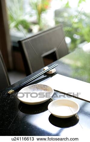 Stock Image - Chopsticks and saucers on table in restaurant. Fotosearch