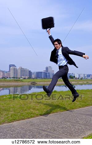 Young businessman jumping with briefcase View Large Photo Image Stock Image - Young businessman jumping with briefcase. Fotosearch