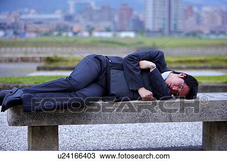 Young businessman lying on bench sleeping View Large Photo Image Stock Image - Young businessman lying on bench sleeping. Fotosearch